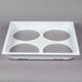 A white plastic tray with four circles.