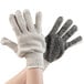 A pair of hands wearing Cordova work gloves with black PVC dotted palms.