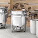 A Choice stainless steel soup chafer with a white bowl on top.
