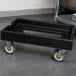 A black rectangular Cambro cart with wheels.