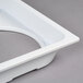 A white rectangular plastic lid with four holes.
