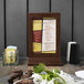 A Menu Solutions walnut wood menu tent on a table.