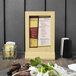 A Menu Solutions natural wood menu tent on a table.