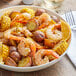 A bowl of shrimp, corn and potatoes with Regal Upper Bay Crab Mix on a table.