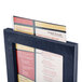 A Menu Solutions wood menu tent in a black frame holding a menu.