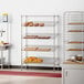 A bakery display of Regency slanted wire shelves filled with pastries.