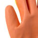 A close up of a Cordova medium warehouse glove with yellow tips and an orange palm.