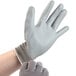 A person wearing a pair of grey Cordova Cor-Touch Lite gloves with a grey palm coating.