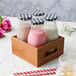 A wooden crate with Acopa milk bottles and a checkered cloth