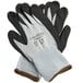 A pair of gray and black gloves with white trim on the wrist.