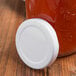 An Acopa milk bottle with a white lid on a wooden surface.