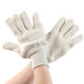 A pair of hands wearing Cordova Loop-Out natural terry work gloves.