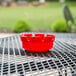 A red Choice plastic ashtray on a table.