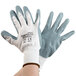 A person wearing white Cordova Cor-Touch foam nitrile gloves with gray foam nitrile palms.