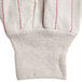 A white Cordova jersey work glove with red stitching on the palm.