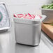 A Choice stainless steel steam table pan with radishes and green beans on a counter.