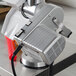 A close-up of a silver Weston Roma motor attachment with a red handle.