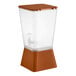 A 5-gallon brown beverage or juice dispenser with a clear container and brown base and lid.