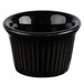 A Tuxton black fluted china ramekin with a black rim.