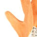 A close up of a large orange Cordova Ruffian warehouse glove with jersey lining.