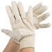 A pair of hands wearing Cordova medium weight cotton canvas gloves.