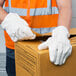 A man wearing Cordova heavy weight work gloves opening a box.