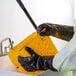 A pair of black PVC gloves being worn while handling a yellow cleaning bucket.