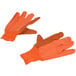 A close-up of a pair of Cordova orange canvas work gloves with black dots.
