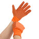 A pair of large orange Cordova canvas work gloves with black PVC dots.