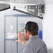 A man using a Curtron Polar-Pro swinging door with his hand.