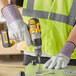 A person using Cordova leather work gloves to drill holes in a metal surface.