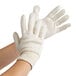 A pair of hands wearing Cordova white jersey gloves.