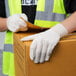 A person wearing Cordova Natural Cotton Jersey Gloves and holding a box with a white glove.