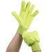 A pair of hands wearing hi-vis yellow Cordova work gloves.