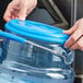 A person holding a San Jamar blue Snap-Tight lid on a plastic container.