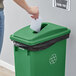 A green rectangular recycling trash can with a paper slot lid and a recycling symbol on the front.