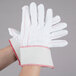 A pair of Cordova Natural Nap-In work gloves with red stitching.