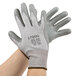 A pair of hands wearing gray Cordova HPPE gloves with gray polyurethane palm coating.