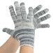 A pair of hands wearing Cordova heavy weight work gloves with grey and white stripes.