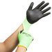 A pair of Cordova Hi-Vis Lime gloves with black and green trim on a person's hands.