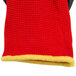 A close-up of a red and yellow glove with a yellow stripe on the wrist.