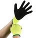 A pair of hands wearing green and black Cordova Charger gloves.