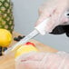 A person using a Choice serrated utility knife to cut a lemon.