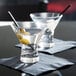 Two Anchor Hocking mini martini glasses filled with liquid and olives.