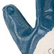 A close up of a blue Cordova nitrile glove with white jersey lining.