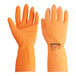 A close-up of a pair of orange Cordova rubber gloves.