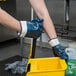 A person wearing Cordova Smooth Supported Nitrile Gloves holding a yellow bucket.