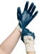 A pair of hands wearing blue Cordova smooth supported palm coated nitrile gloves.