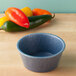 A blue HS Inc. polyethylene ramekin on a wood surface.