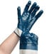 A hand wearing blue and white Cordova warehouse gloves.